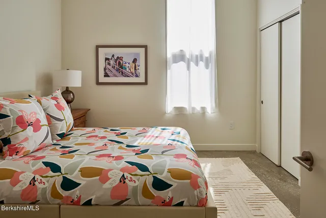 a bedroom with a bed and a painting on the wall