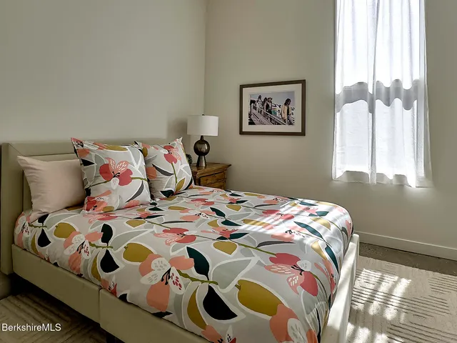 a bedroom with a bed and a painting on the wall