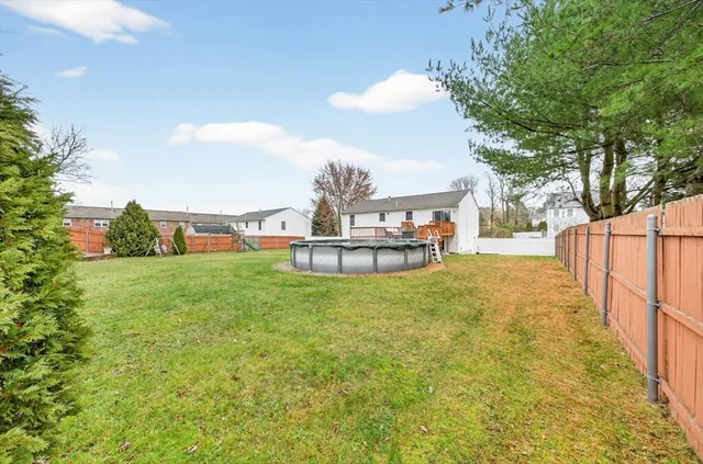 a view of a backyard with fountain plants and large tree