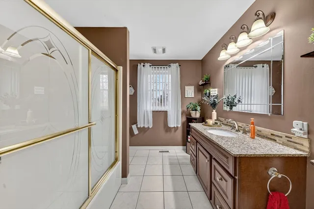 a bathroom with a granite countertop sink and a mirror