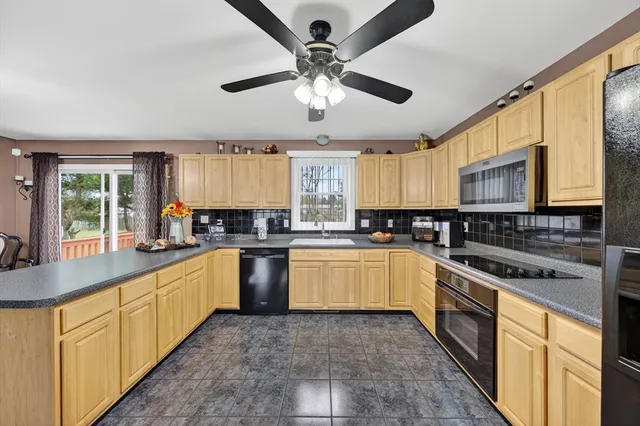 a large kitchen with stainless steel appliances granite countertop a stove sink and cabinets