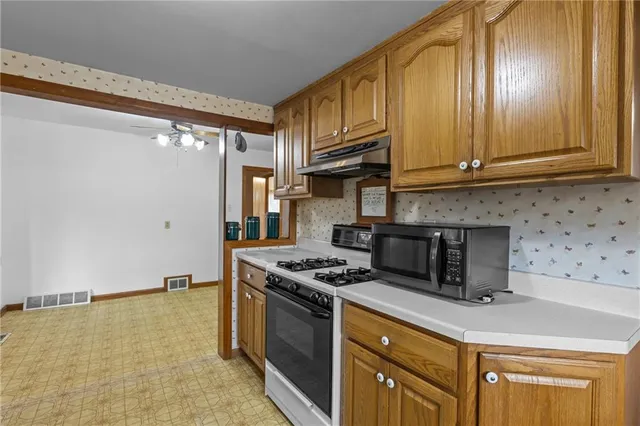 a kitchen with stainless steel appliances granite countertop a stove a sink and a refrigerator