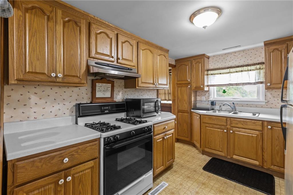 319 Center Grange Road Monaca, PA 15061 - Photo 9 of 24 a kitchen with stainless steel appliances granite countertop a stove a sink and a microwave