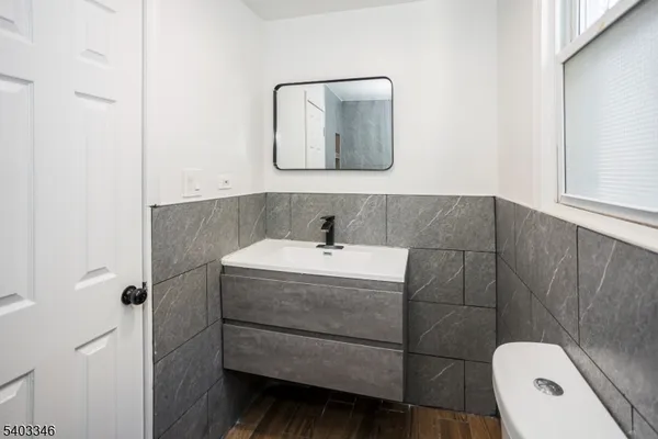 a bathroom with a sink a toilet and mirror