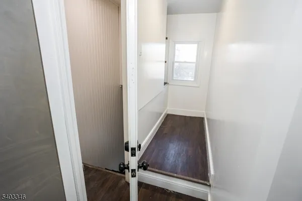 a view of a hallway with wooden floor and entryway