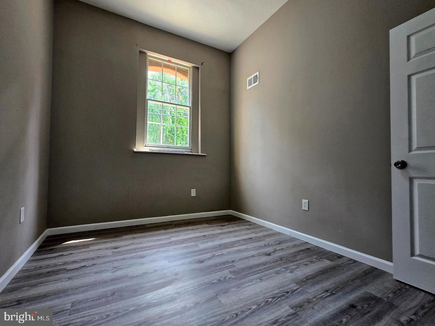 1218 North 16th Street Philadelphia, PA 19121 - Photo 18 of 33 a view of an empty room with wooden floor and a window