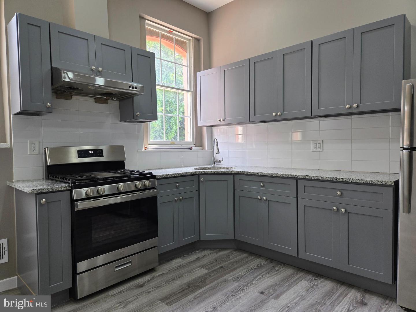1218 North 16th Street Philadelphia, PA 19121 - Photo 3 of 33 a kitchen with stainless steel appliances granite countertop a stove a sink and a microwave