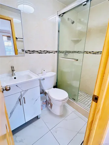 a bathroom with a sink a toilet a mirror and shower