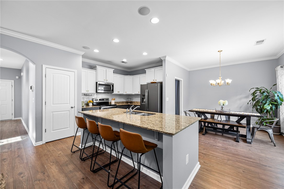 719 Camberwell Road Simpsonville, SC 29680 - Photo 3 of 47 Gleaming stone countertops and warm wood floors define this open kitchen and dining layout.