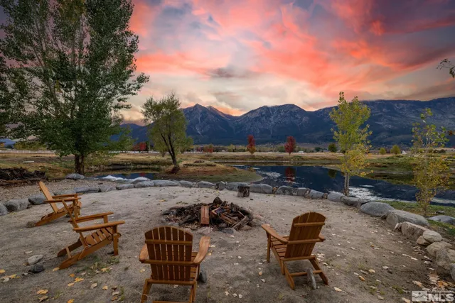 a view of a backyard with table and chairs with wooden fence
