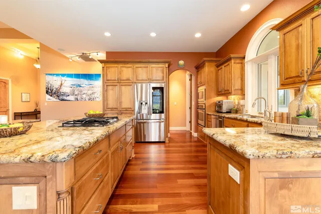 a large kitchen with stainless steel appliances granite countertop a large stove a sink and a refrigerator