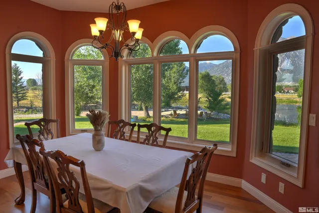 a view of a dining room with furniture large windows and wooden floor