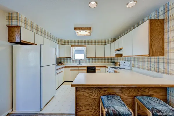 a kitchen with a refrigerator a stove a sink dishwasher and wooden cabinets