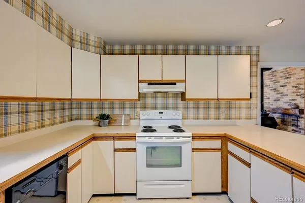 a kitchen with a sink cabinets and white appliances