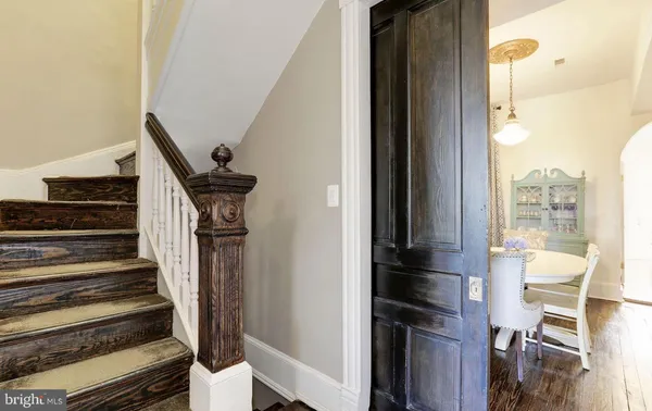 a view of staircase with lots of frames on wall and a window
