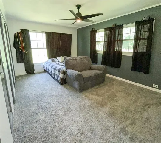 a spacious bedroom with a bed and large windows