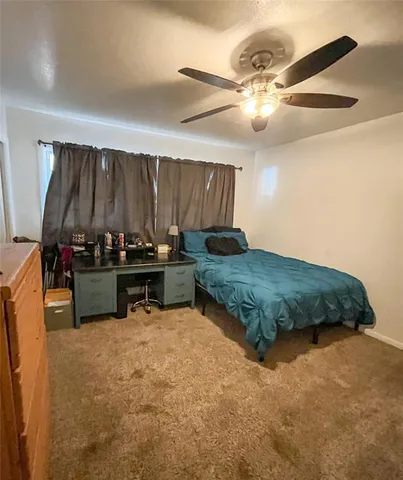 a bedroom with a bed and a ceiling fan