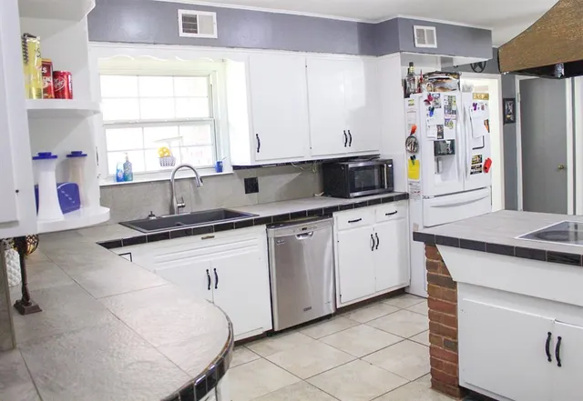 a kitchen with stainless steel appliances granite countertop a sink stove and cabinets