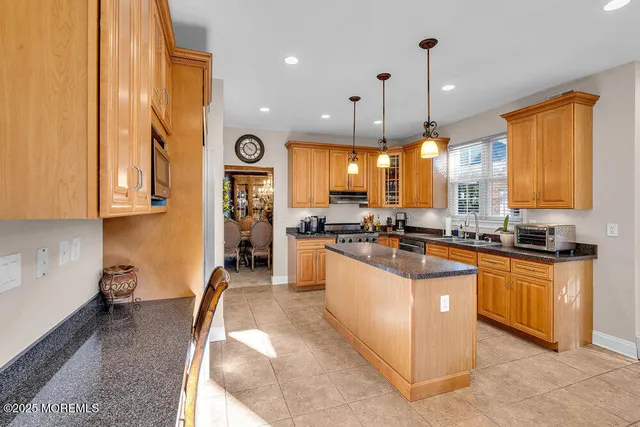 a kitchen with stainless steel appliances granite countertop a stove a sink a refrigerator and a microwave