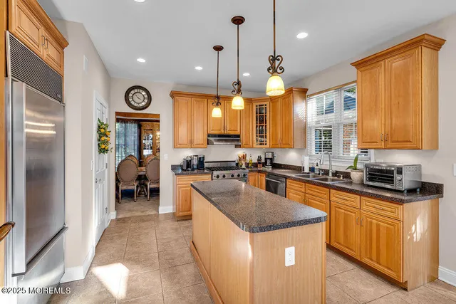 a kitchen with stainless steel appliances granite countertop a sink a stove and a wooden floors