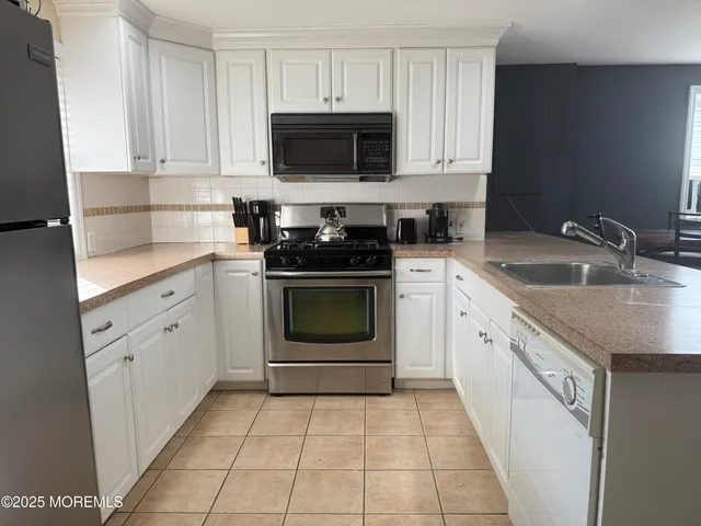 a kitchen with cabinets stainless steel appliances and a sink