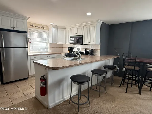 a kitchen with refrigerator and chairs