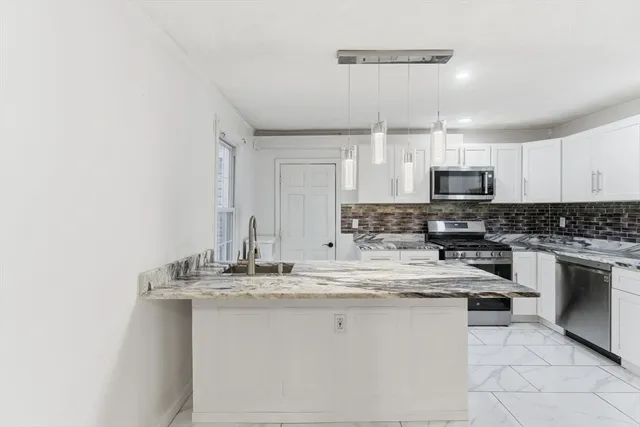 a kitchen with stainless steel appliances granite countertop a refrigerator sink and stove
