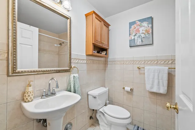 a bathroom with a toilet a sink and a mirror