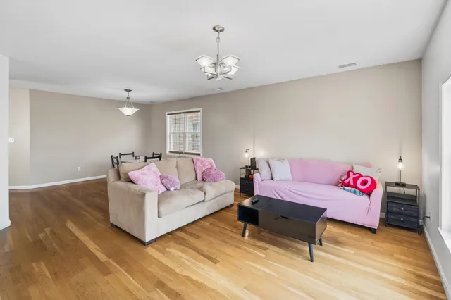 a living room with furniture and a chandelier