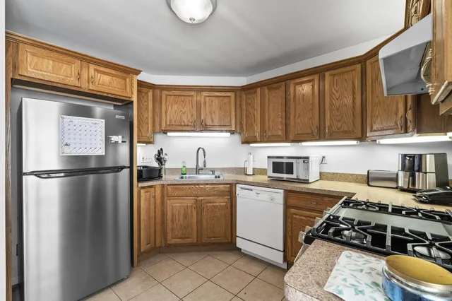 a kitchen with stainless steel appliances a stove a sink and a refrigerator