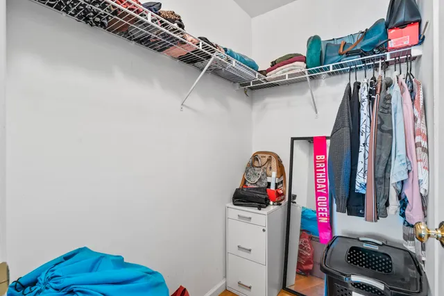 a view of walk in closet with clothes and shoes