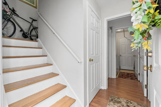 a view of a hallway with wooden floor and stairs