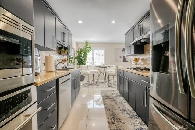 a kitchen with stainless steel appliances granite countertop a sink stove and cabinets