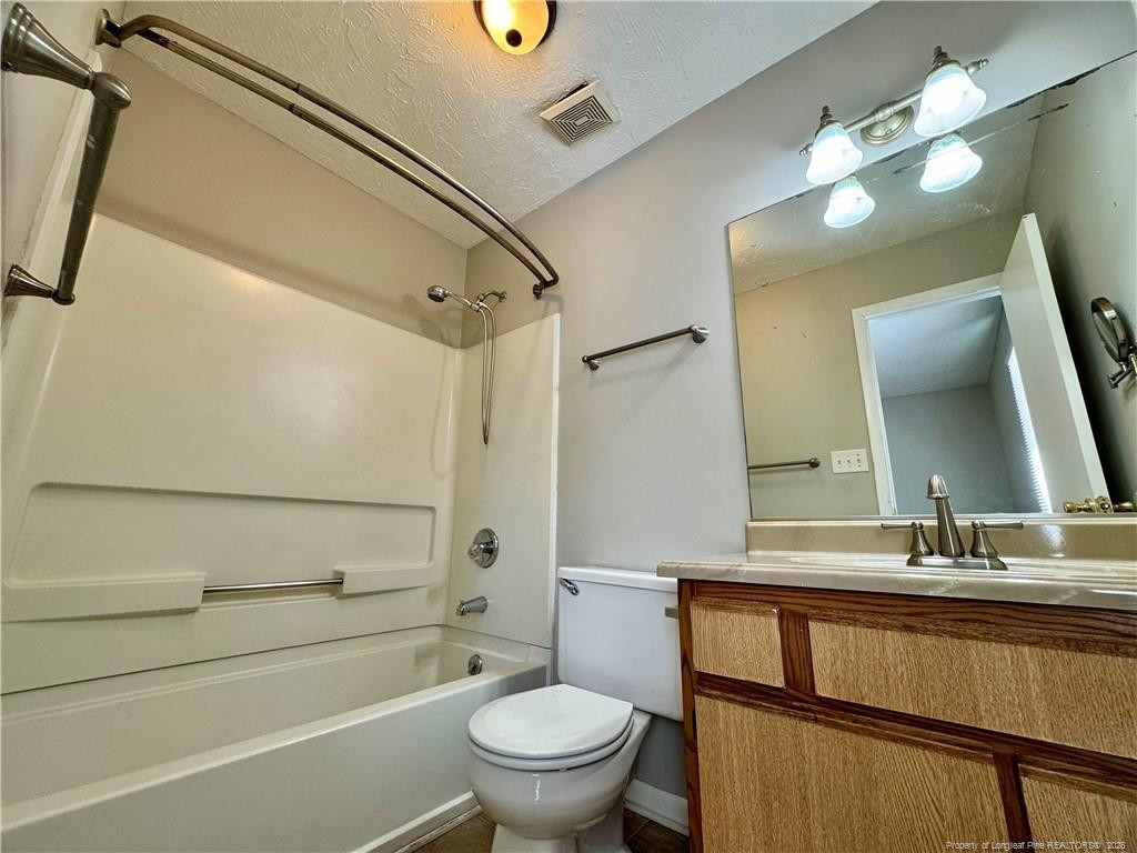 3323 Balero Court Spring Lake, NC 28390 - Photo 15 of 16 a bathroom with a granite countertop toilet a sink and a mirror