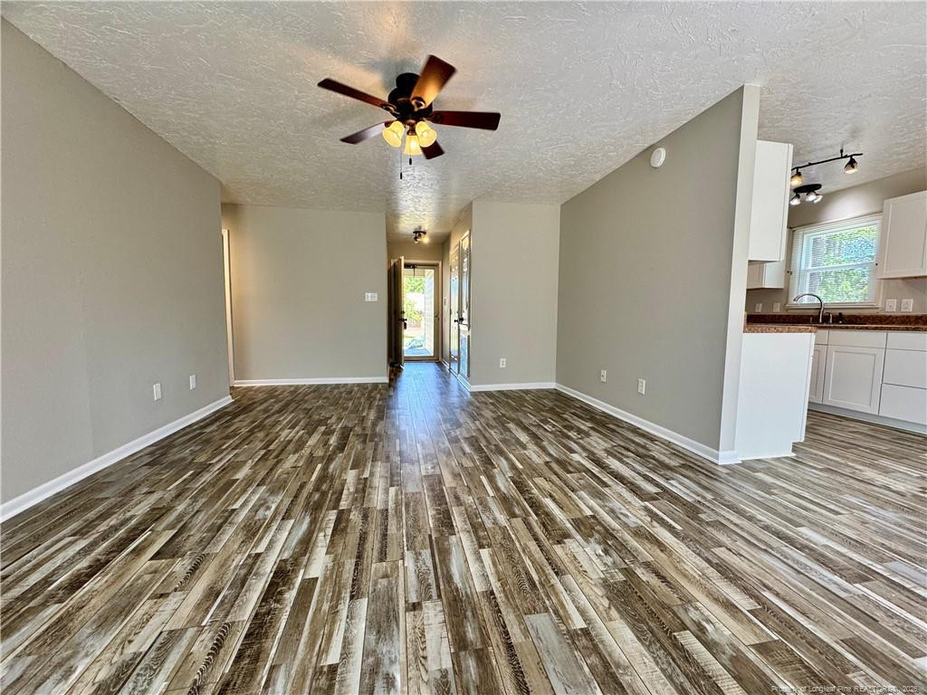 3323 Balero Court Spring Lake, NC 28390 - Photo 5 of 16 a view of an empty room with wooden floor and a kitchen