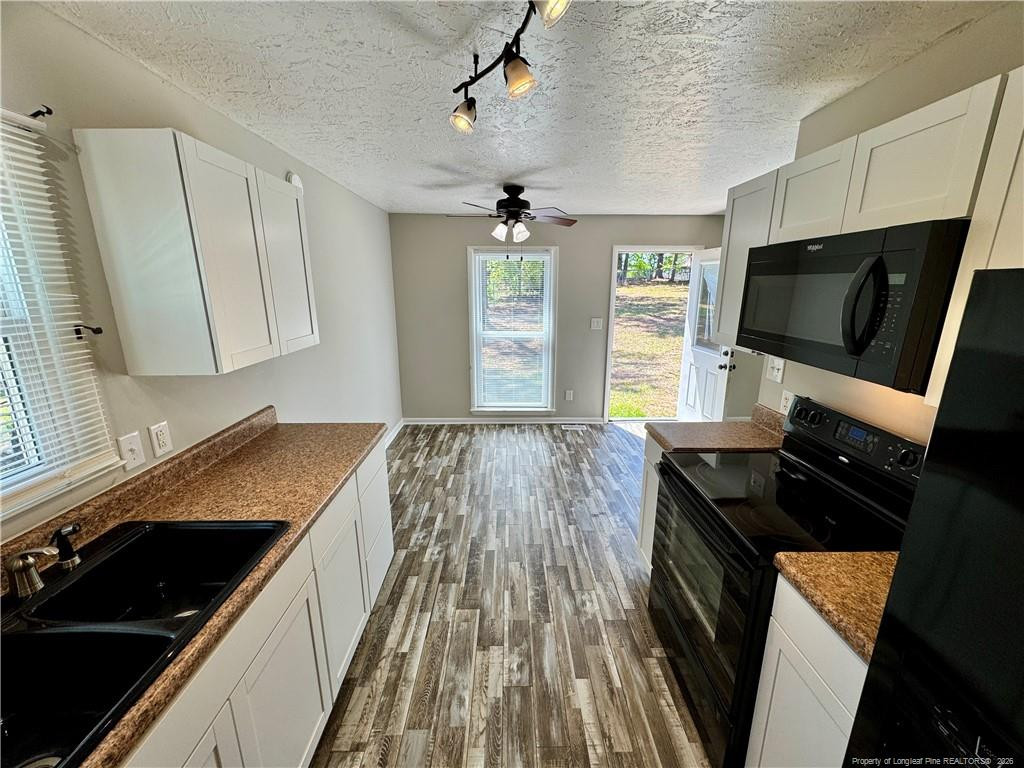 3323 Balero Court Spring Lake, NC 28390 - Photo 8 of 16 a kitchen with granite countertop a stove sink and microwave