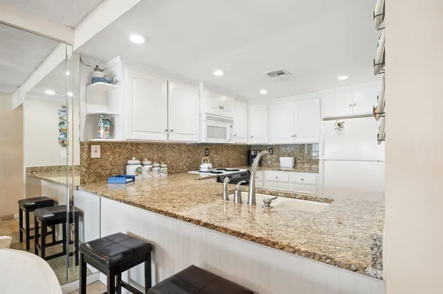 a kitchen with white cabinets and appliances