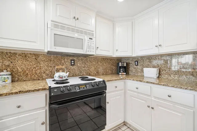 a kitchen with granite countertop a sink and cabinets
