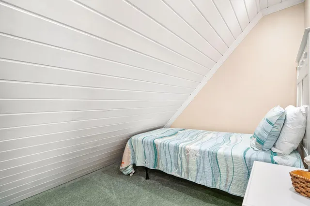 a bed sitting in a bedroom next to a window