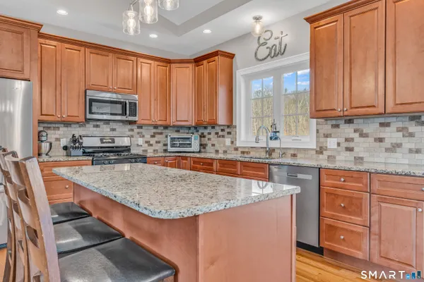 a kitchen with stainless steel appliances granite countertop a sink stove and refrigerator