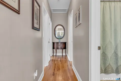 a view of a hallway with wooden floor and a door