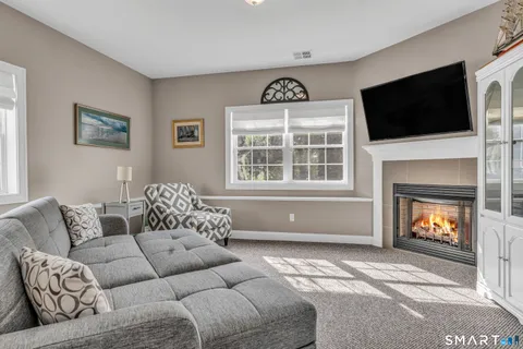 a living room with furniture a flat screen tv and a fireplace