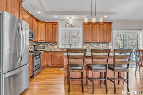 a kitchen with stainless steel appliances a table chairs and a refrigerator