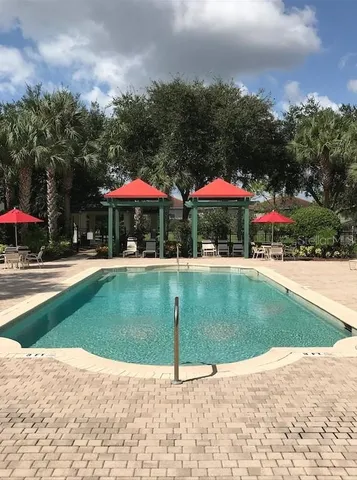 a view of patio with chairs and umbrellas on a sidewalk