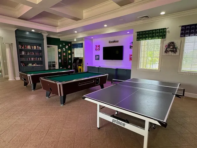 a room with pool table and windows