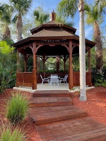 a view of patio with table and chairs under an umbrella with a small yard