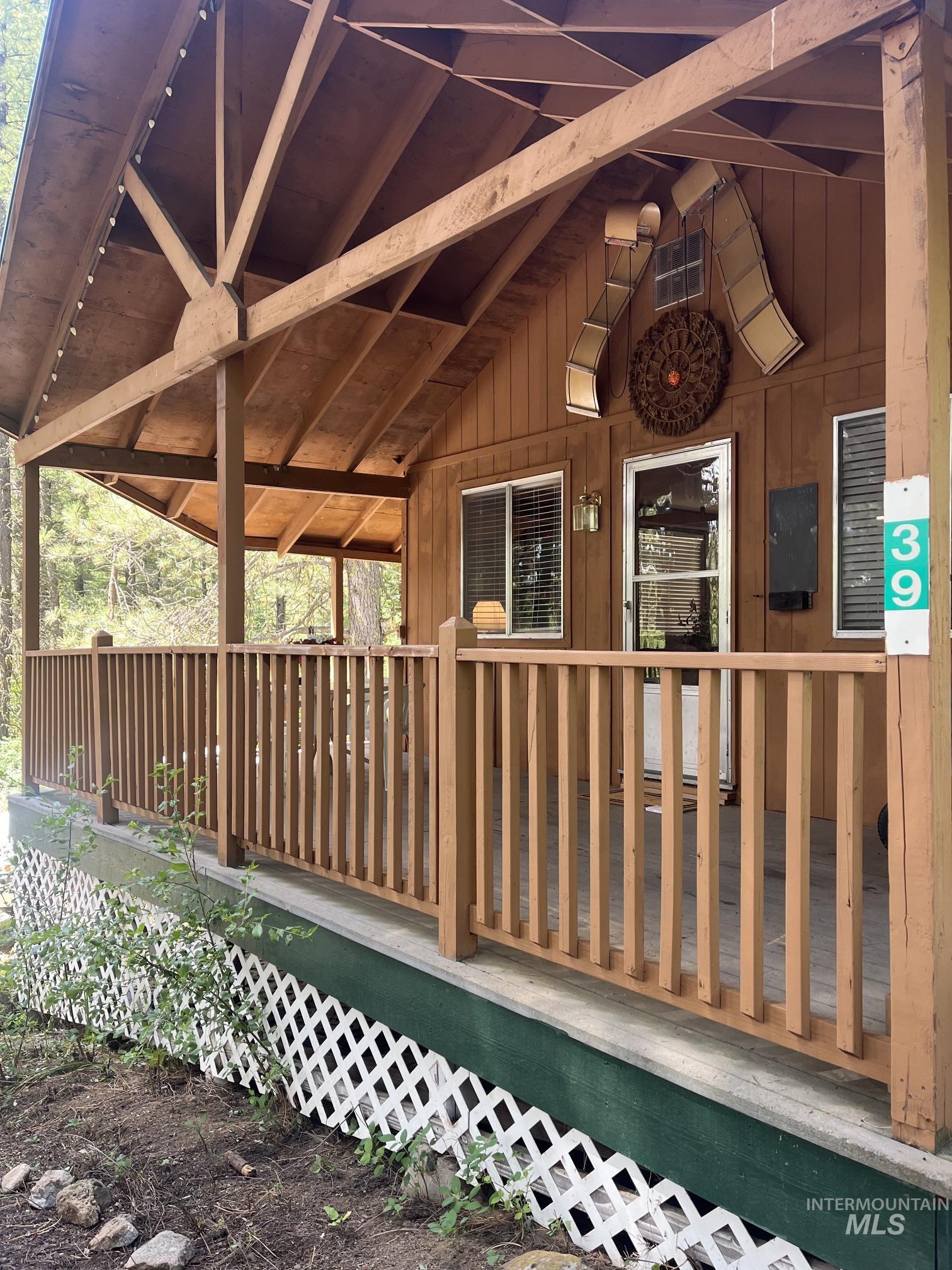 39 Mayflower Mine Road Placerville, ID 83666 - Photo 1 of 36 Wood-sided residence featuring a covered front porch with a wooden railing