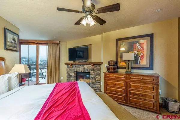 a bedroom with a large bed and a flat tv screen on dresser