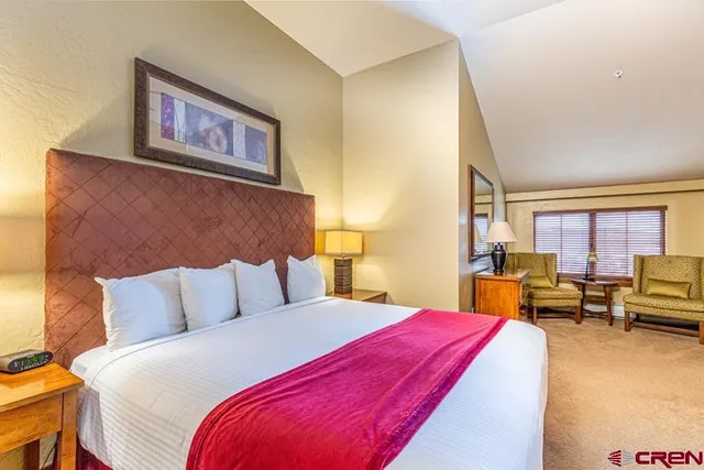 a bedroom with bed and wooden floor