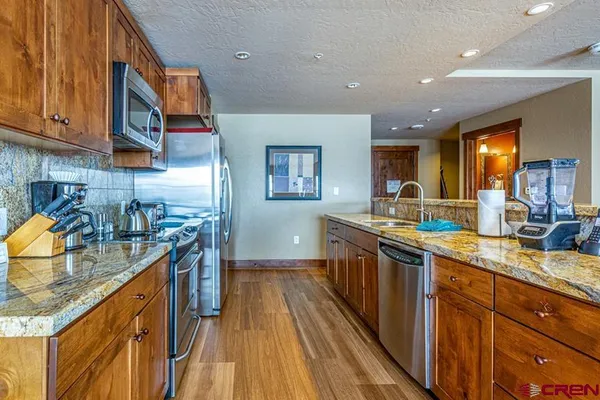 a kitchen with stainless steel appliances granite countertop a sink and stove top oven
